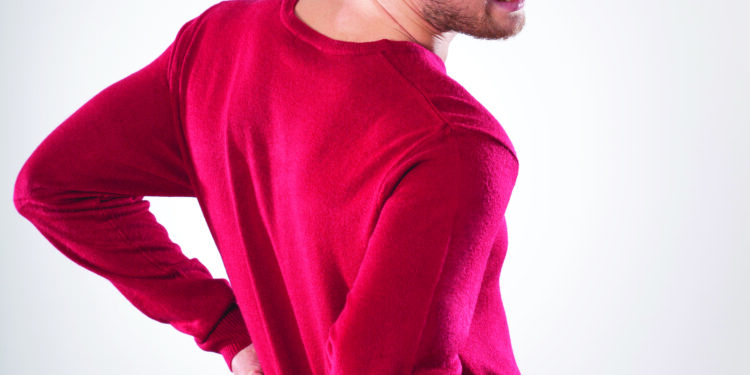 Jeune homme courbaturé se tenant le dos