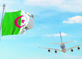 Drapeau algérien avec avion qui décolle en arrière-plan