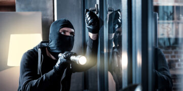 Cambrioleur tentant une effraction dans une maison