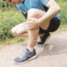 Personne tenant sa jambe pour soulager une crampe musculaire