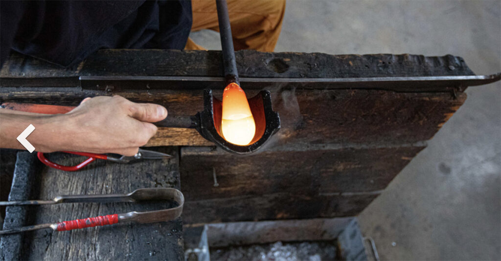 Verre en fusion façonné dans un moule en bois au CIAV de Meisenthal, lors de la fabrication d’une boule de Noël.