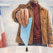 Homme déposant un bulletin de vote bleu clair dans une urne, illustration crayonnée des élections municipales 2026 et de la présidentielle 2027 en France.