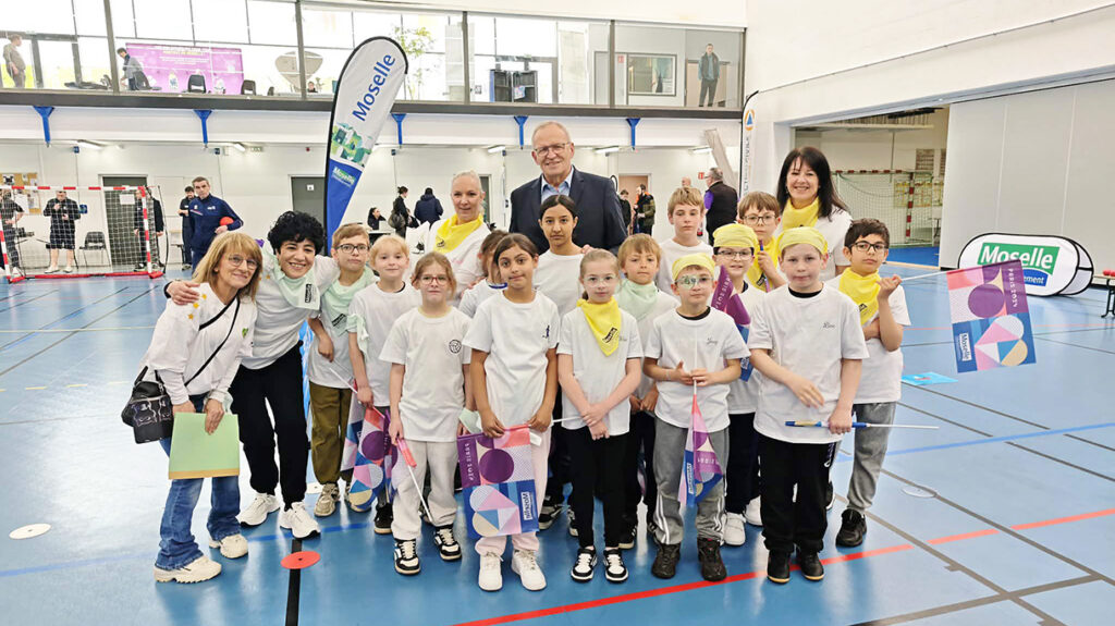 Enfants participants aux MECS Olympics 2026 à Thionville entourant Patrick Weiten dans le gymnase de la Milliaire