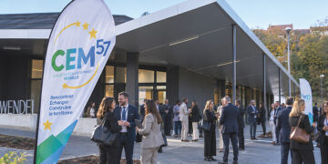 CEM57 2026 devant l’Espace De Wendel à Hombourg-Haut, avec des chefs d’entreprise et acteurs économiques réunis devant l’entrée (simulation IA)
