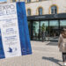 Une femme tenant le flyer Expo Bleus devant La Citadelle à Metz